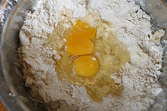 Zwei Eier zum Butter-Mehl-Gemisch geben