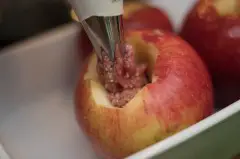 Die Fülle in die ausgehöhlten Äpfel füllen.