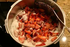 Die geschnittenen Erdbeeren und den Zucker vermischen