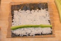 Die Gurkenstreifen auf dem Reis platzieren und die Maki-Rolle mit den Gurken-Fülle formen.