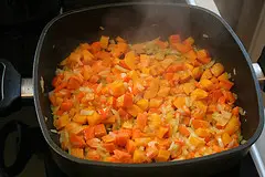 Zwiebel, Karotten und Kürbis in Öl braten.