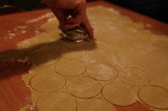Den Teig ausrollen und mit einer runden Form Kekse ausstechen (die Hälfte mit Löchern)
