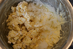 Blauschimmelkäse, Camembert und Zwiebel mit der geschlagenen Butter vermischen