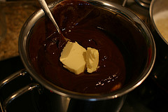Die Schokolade im Waserbad mit Butter schmelzen