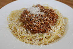 Das fertig gekochte Ragù alla bolognese mit Spaghetti, angerichtet mit Parmesan