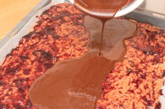 Die flüssige Schokolade etwas abgekühlt auf der Marmelade verteilen.