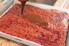 Die flüssige Schokolade etwas abgekühlt auf der Marmelade verteilen.
